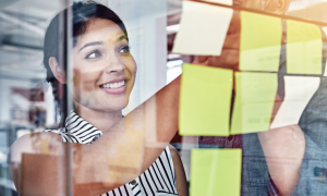 image of a woman creating a kanban board with sticky notes
