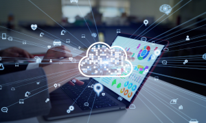 Image of a cloud with a slightly faded image of a laptop in the background to depict "Unleashing the Power of Composable SaaS Solutions"