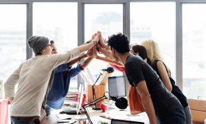 Image of a team all coming together for a team high-five to depict "Unparalleled Partner Support and Global Reach"